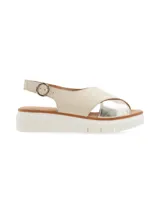 Sandalia con plataforma color beige y plateado, con tiras cruzadas y hebilla metálica de ajuste.