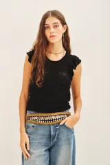 Musculosa negra tejida en hilo de algodón con punto desagujado, calce al cuerpo y volados en las sisas.