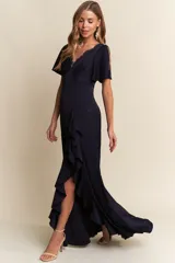 Vestido largo de color azul marino, con escote en V con detalle de encaje, mangas cortas con abertura y falda con tajo lateral y volados.