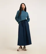 Sweater negro de punto con cuello redondo, puños y ruedo acanalados. Incluye cuello, puños y ruedo de camisa celeste a rayas.