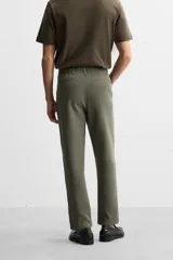Pantalón de jogging color beige confeccionado en tejido de mezcla de algodón. Cuenta con cintura elástica ajustable con cordón, bolsillos frontales y traseros.