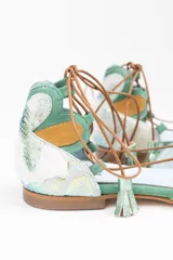 Bailarinas con estampado multicolor, puntera y talón combinan 3 capas de tejido superpuesto de forma manual. Cordones de algodón rematados con borlas de ante verde, en contraste.