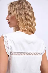 Chaleco blanco con escote en V, detalle de encaje y lazos en el frente.