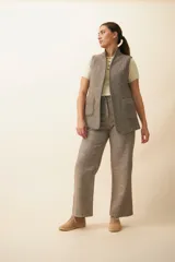 Chaleco color beige, entallado, con solapa, bolsillos plaqué y terminaciones envivadas.