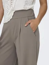 Pantalón de vestir de tiro alto, color gris topo, con pliegues frontales y calce ancho y fluido.