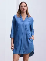 Vestido corto de tencel color azul denim, con cuello solapa, escote en V y mangas 3/4 regulables con presilla y botón.