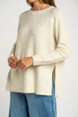 Sweater color beige de tejido texturado, con cuello redondo y mangas largas.