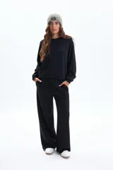 Pantalón deportivo negro de tiro alto, corte ancho y pierna recta, con bolsillos laterales.