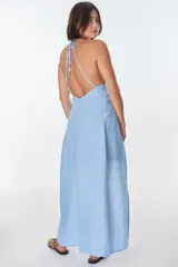 Conjunto de top halter con abertura en el abdomen y falda cruzada con ruedo desflecado, color fucsia.