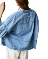 Blusa celeste de denim, manga larga abullonada, escote en V y corte holgado.