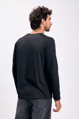 Remera negra de manga larga con cuello redondo.