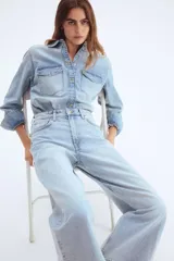 Pantalón de jean celeste de corte ancho, tiro alto y largo tobillero.