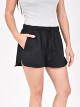 Short negro de tela suave con cintura elástica ajustable con cordón, bolsillos laterales y corte redondeado en los laterales.