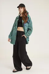 Pantalón de calce ancho y fluido en color negro, confeccionado en tejido de cupro. Presenta bolsillos laterales tipo cargo y un diseño de tiro alto.