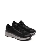 Championes Umbro modelo Adventure para hombre, color negro con detalles en gris oscuro. Presentan una capellada de malla transpirable con refuerzos sintéticos y la marca Umbro en relieve sobre el lateral. La suela es gruesa, de color gris claro, con una base negra.