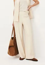 Pantalón de vestir color beige, de corte recto y tiro alto, con bolsillos laterales y traseros.