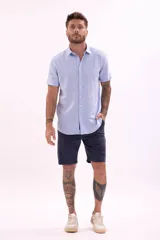 Camisa celeste de lino de manga corta con cuello clásico y cierre con botones.