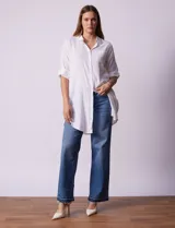 Camisola larga de algodón color blanco, marca Dash. Tiene cuello con solapa, abertura central con botones, bolsillo aplicado en el pecho, mangas regulables con presilla y botón, y bolsillos laterales en la costura.