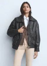 Pantalón de jean color beige claro, tiro medio, estilo campana (flare) con bajo deshilachado y cinco bolsillos.