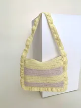 Cartera tejida a crochet con hilo 100% de algodón, con diseño a rayas y volados bordeando la cartera extendiéndose hacia la manija.