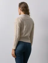 Cardigan color beige en tejido jacquard, con cuello con solapa y abertura central con cierre. Delantera con bolsillos simulados.
