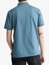 Chomba azul de manga corta con cuello polo y tapeta de dos botones. Logo de Calvin Klein bordado en el pecho. Corte regular.