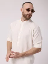 Camisa de lino color crudo, de manga larga con puños abotonados y cuello mao.