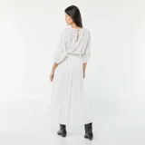 Vestido largo blanco con bordado inglés, escote en V, mangas 3/4 y corte en la cintura con abertura.