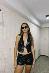 Short negro de cuero sintético con cintura alta y cordones cruzados en el frente.