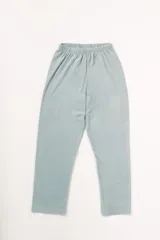 Pijama celeste de terciopelo, compuesto por una camisa de manga larga con botones y vivo blanco, bolsillo en el pecho y un pantalón recto con elástico en la cintura.