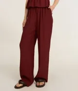 Pantalón recto color borgoña, confeccionado en viscosa texturizada, con lazo en la cintura.