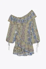 Vestido corto con estampado paisley en tonos ocre, azul y marrón. Tiene escote recto con volantes, mangas largas abullonadas con puños elásticos y cintura elástica.