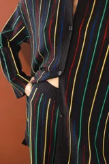 Camisa tejida color borgoña con rayas verticales blancas, escote redondo, botones frontales, mangas anchas 3/4 y aberturas laterales.