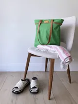 Bolso de lona color negro con detalles en cuero marrón, con bolsillo interno y forro de tela.