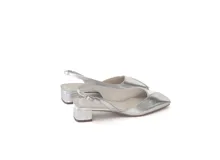 Zapato slingback plateado de cuero, con punta cuadrada y escote en V. Tiene pulsera trasera con elástico y taco bajo cuadrado forrado en cuero.