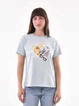 Remera celeste con estampado de una bolsa de red con naranjas, lentes de sol y un pañuelo.
