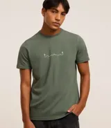 Remera verde militar de algodón, corte regular, cuello redondo, manga corta y estampa frontal con diseño de montañas y excursionistas en línea continua blanca.