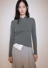 Camiseta gris con cuello redondo y capucha, de tejido fluido y corte entallado, con mangas largas.