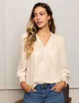 Blusa color beige de gasa con escote en V, apliques de botones y detalle de punto smock en hombro y puño.