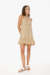 Vestido corto color beige, con escote halter, corte suelto y falda con volados.