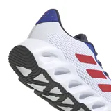 Championes Adidas Switch Run blancos con detalles en azul, gris y naranja. Presentan las tres tiras características de la marca en color rojo.