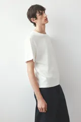 Remera blanca de algodón de peso medio, con cuello redondo ribeteado acanalado y bajo recto.