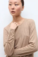 Remera de manga larga color tostado melange, con cuello redondo y calce al cuerpo.