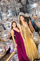 Vestido largo con escote en V, estampado en tonos rojizos y rosados, con un patrón ondulado. Presenta cut-outs laterales bajo el busto y breteles finos que se cruzan en la espalda.