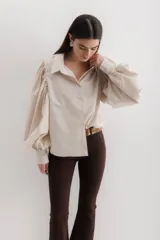 Camisa color beige de algodón con mangas abullonadas y cierre con botones.