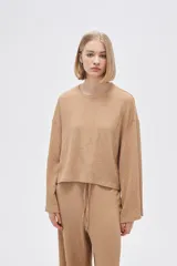 Top color beige de manga larga, holgado y cuello redondo.
