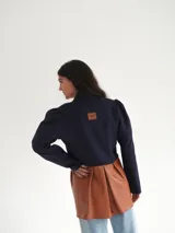 Blazer azul marino corto de lana con cuello solapa y mangas abullonadas.