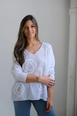 Remera blanca de algodón con cuello en V y mangas 3/4. Presenta apliques de rombos blancos en relieve.