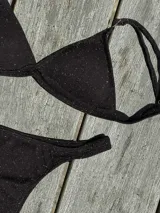 Conjunto de bikini turquesa con corpiño triangular de corte fijo, breteles regulables y almohadillas desmontables, y bombacha vedetina con frunce elástico en los costados.