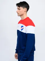 Buzo de felpa con cortes y cambios de color rojo, blanco y azul. Incluye el escudo del Club Nacional de Football y las siglas C.N.deF.